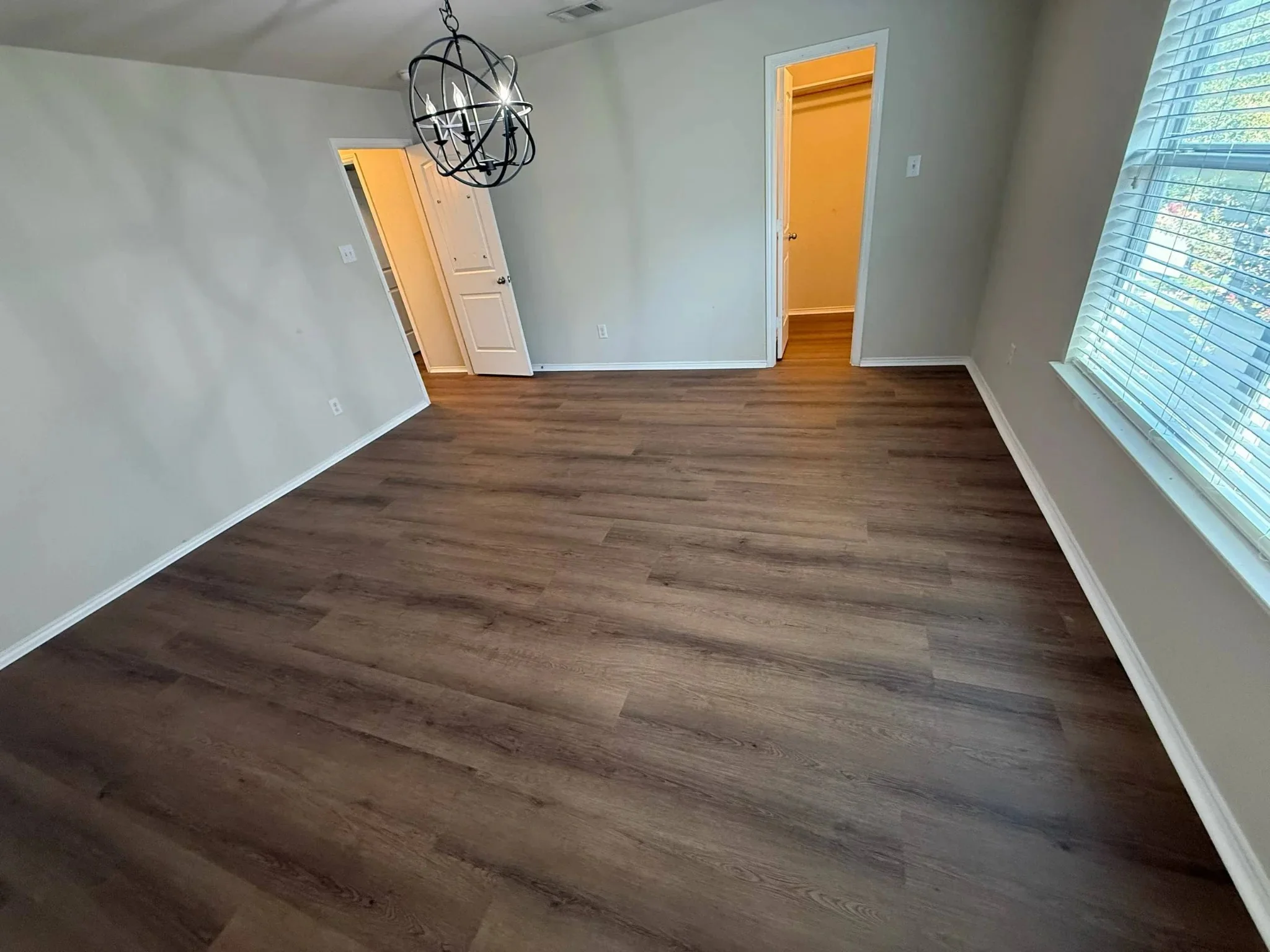 Bedroom with mid-brown wood-look plank flooring