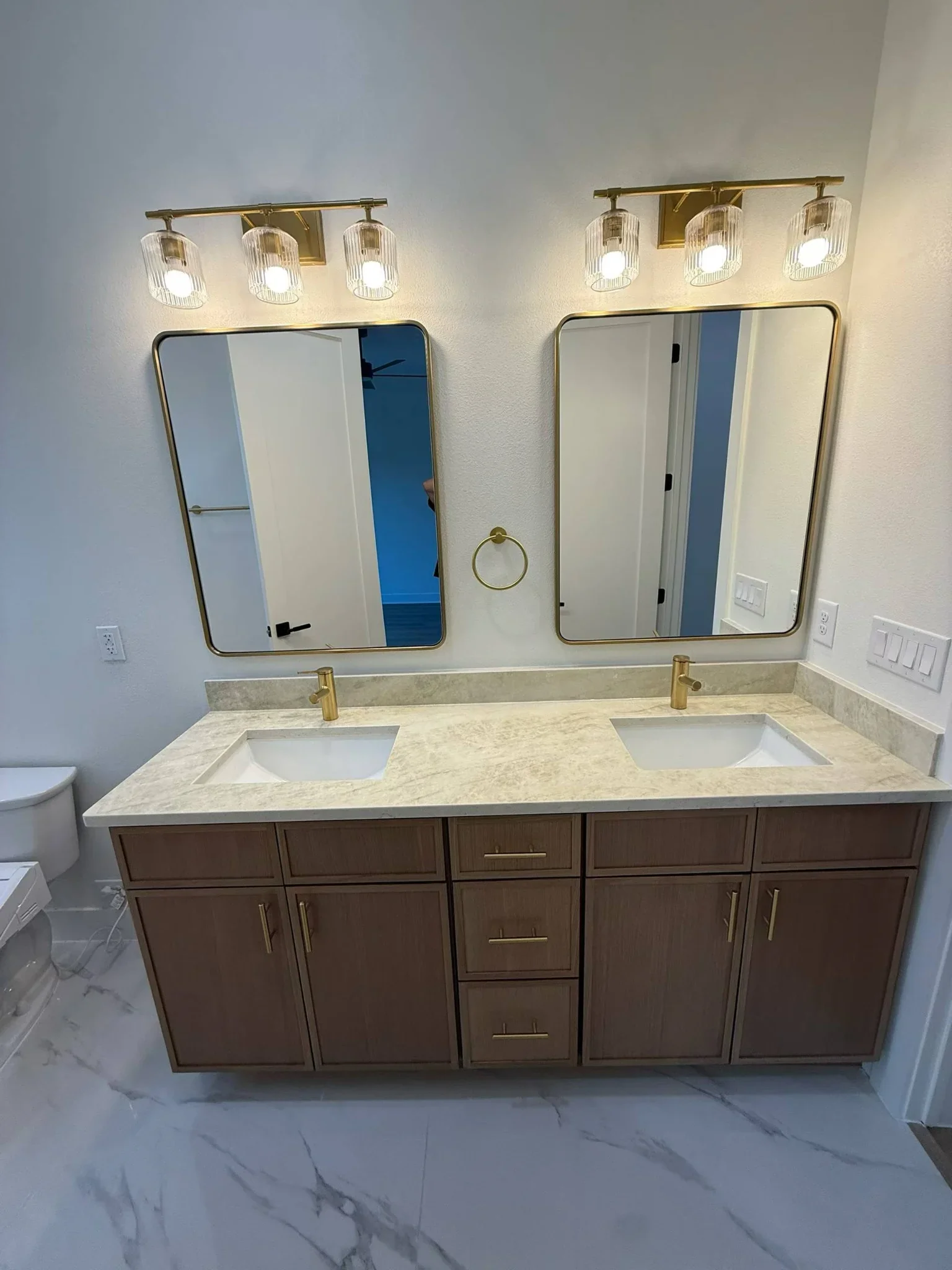 Natural wood double bathroom vanity with brass hardware and mirrors