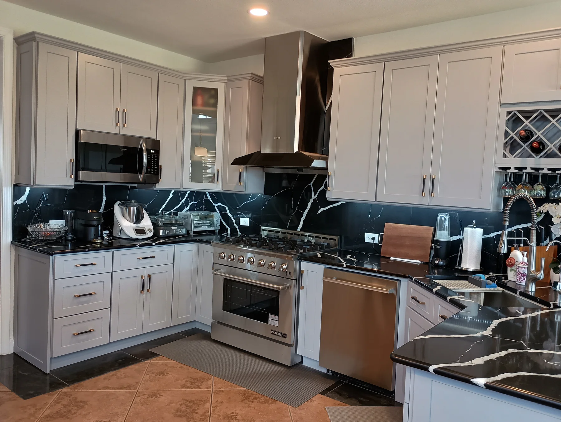 Gray shaker kitchen cabinetry with marble-look backsplash