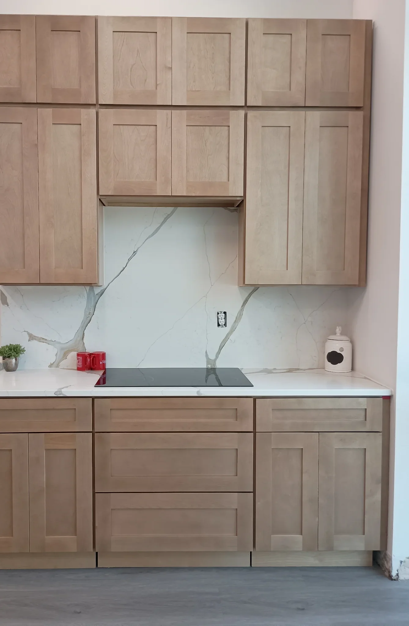 Blonde oak cabinet display with marble slab backsplash