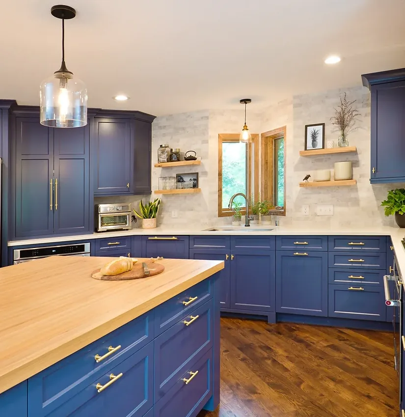 Blue shaker kitchen cabinetry with wood island top